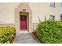 Inviting entrance showcasing a red front door, well-maintained landscaping, and a welcoming walkway at 2867 Club Cortile Cir, Kissimmee, FL 34746