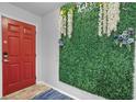 A bright entryway with a red door, stylish green wall decor, and a welcoming blue rug at 2867 Club Cortile Cir, Kissimmee, FL 34746