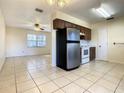 Open-concept kitchen featuring stainless steel appliances and tile flooring, flowing into a bright living area at 430 Short Dr, Kissimmee, FL 34759