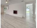 Bright living room featuring a painted brick fireplace, neutral walls, and sleek, modern flooring at 4521 Alrix Dr, Orlando, FL 32839
