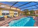 The screened-in pool and hot tub features a brick patio with lounge furniture and open backyard at 477 Orange Cosmos Blvd, Davenport, FL 33837