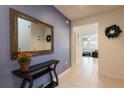 Inviting foyer with a large decorative mirror, a sleek console table, and tile flooring at 5231 Wildwood Way, Davenport, FL 33837