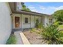 Welcoming front entry featuring a decorative wood door and vibrant landscaping for added charm at 878 Elgin Dr, Winter Springs, FL 32708