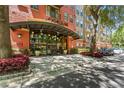Stylish condo building entrance with glass doors, lush landscaping, and clear signage for Uptown Place at 911 N Orange Ave # 321, Orlando, FL 32801
