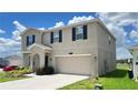 Two-story home with a two car garage, arched entry and manicured landscaping at 1343 Lassen St, Haines City, FL 33844