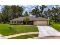 Charming single-story home with a well-manicured lawn and a two car garage at 1405 Ashbury Ct, Lakeland, FL 33809