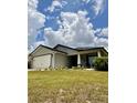 Charming single-story home with a well-manicured lawn and a two-car garage, showcasing inviting curb appeal at 144 Foxtail Loop, Davenport, FL 33837
