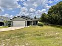 Charming single-story home with a well-manicured lawn and a two-car garage, showcasing inviting curb appeal at 144 Foxtail Loop, Davenport, FL 33837