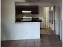 Kitchen with breakfast bar, tiled floor and dark cabinets at 2002 Cascades Blvd # 108, Kissimmee, FL 34741