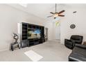 Bright living room with a high ceiling, neutral carpet, a ceiling fan, and entertainment center at 2263 Mallory Cir, Haines City, FL 33844