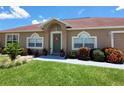Inviting front entrance with well-maintained lawn, blooming bushes, and a decorative wreath on the green front door at 2357 Great Harbor Dr, Kissimmee, FL 34746
