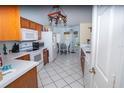 Cozy kitchen with white appliances, tile flooring, and an adjacent dining nook at 2773 Woodstream Cir, Kissimmee, FL 34743