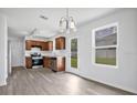 Well-lit kitchen with stainless steel appliances, wood cabinets, vinyl floors, and a view to the backyard at 303 Anchovie Ct, Poinciana, FL 34759