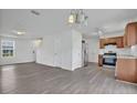 Open-concept kitchen and living area featuring stainless steel appliances, and light gray vinyl flooring at 303 Anchovie Ct, Poinciana, FL 34759