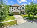 Charming two-story home featuring a well-manicured lawn and a welcoming front porch with columns and a two car garage at 3144 Dark Sky Dr, Harmony, FL 34773