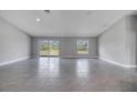 Bright, spacious living room with tile flooring, large sliding glass doors, and neutral color scheme at 33 Peterlee Ct, Kissimmee, FL 34758