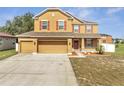 Attractive two-story home with a red door, three-car garage, and verdant lawn at 355 Churchill Ct, Kissimmee, FL 34759