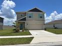 Charming two-story home with a manicured lawn, two-car garage, and tasteful landscaping at 464 Talisi Loop, St Cloud, FL 34771