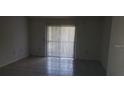 Bright living room featuring tile floors, vertical blinds, and sliding glass doors providing natural light at 5287 Images Cir # 307, Kissimmee, FL 34746