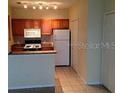 Cozy kitchen features white appliances and wood cabinets at 6137 Metrowest Blvd # 308, Orlando, FL 32835