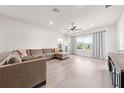 Bright and airy living room featuring a large sectional sofa, neutral color palette, and ample natural light at 7413 Bent Tree Loop, St Cloud, FL 34771