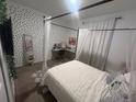 A comfy bedroom featuring a four-poster bed, workspace, and patterned wallpaper, perfect for relaxing at 820 Cambridge Dr, Winter Haven, FL 33881