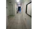Bright hallway with tiled flooring leading to various rooms, decorated with mirror and wall art at 820 Cambridge Dr, Winter Haven, FL 33881