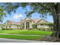 Beautiful single-story home with lush landscaping and manicured lawn offering inviting curb appeal at 8214 Lake Serene Dr, Orlando, FL 32836