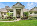 An alluring front entrance highlighted by meticulously manicured landscaping, leading to a stunning single-story home at 8214 Lake Serene Dr, Orlando, FL 32836