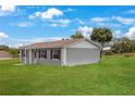 Exterior view of the home with a large yard and mature trees, offering ample space at 1 Coyer Rd, Haines City, FL 33844
