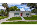 Well-kept one-story home showcases an attached garage, a neatly landscaped yard, and a bright red door at 113 W Division St, Winter Garden, FL 34787