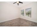 Cozy bedroom with carpet, a ceiling fan, and natural light from the two windows at 1173 Trappers Trail Loop, Champions Gate, FL 33896