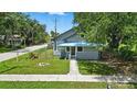 Gray single-story home featuring a fenced yard, blue porch roof, and sidewalk at 1322 New York Ave, St Cloud, FL 34769
