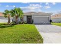 Inviting one-story home with lush green lawn, palm trees, paver driveway, and attached two-car garage at 1416 Oak Marsh St, Davenport, FL 33837