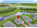 Aerial shot of a home near a tranquil pond, complemented by highway and scenic greenery in the background at 159 Olympus Way, Kissimmee, FL 34759
