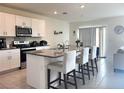 Modern kitchen featuring white cabinets, stainless steel appliances, and a granite countertop island at 1591 Barberry Dr, Kissimmee, FL 34744