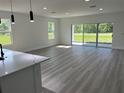 Open-concept living room with wood-look flooring, recessed lighting, large windows, and access to the outside at 202 Bromwich Dr, Kissimmee, FL 34758