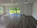 Bright living room featuring an open layout, modern lighting, wood-look floors and sliding glass doors to outside at 202 Bromwich Dr, Kissimmee, FL 34758