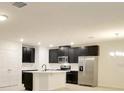 Modern kitchen with stainless steel appliances, a large island, and dark cabinetry at 2833 Noble Crow Dr, Kissimmee, FL 34744