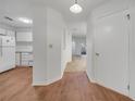 Hallway with wood floors leading to the kitchen and living area with white appliances at 3205 Sabal Palms Ct # A, Kissimmee, FL 34747