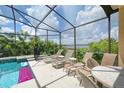 Screened-in pool deck with lounge chairs and view of serene lake and surrounding greenery at 344 Cherokee Ave, Haines City, FL 33844