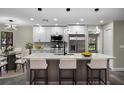 Modern kitchen featuring a large island, stainless steel appliances, and sleek, updated lighting fixtures at 3623 Tree Line Way, St Cloud, FL 34769