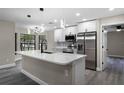 Modern open kitchen with stainless appliances, center island, and stylish light fixtures at 3623 Tree Line Way, St Cloud, FL 34769