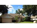 Traditional home with brick accents, mature landscaping, and neutral color scheme, with an arched entryway at 4820 Wingrove Blvd, Orlando, FL 32819