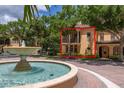 Beautiful two-story, tan-colored home featuring a fountain and mature landscaping enhancing the curb appeal at 502 Mirasol Cir # 103, Kissimmee, FL 34747