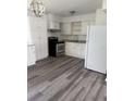 Clean kitchen with white cabinetry, stainless steel appliances, light countertops and dark laminate flooring at 5449 Nw 2Nd St, Ocala, FL 34482