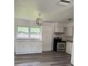 Bright kitchen with white cabinets, modern appliances, and wood-look vinyl flooring at 5449 Nw 2Nd St, Ocala, FL 34482