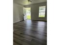 Bright and airy living room with dark laminate flooring, freshly painted walls, and a large window at 5449 Nw 2Nd St, Ocala, FL 34482