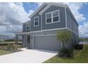 Charming two-story home boasts a two-car garage and manicured front lawn with tasteful landscaping at 5793 Gingham Dr, Kissimmee, FL 34758