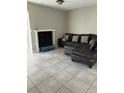 A cozy living room featuring tile flooring, a fireplace, and a comfortable leather sofa with decorative pillows at 5861 La Costa Dr # 115, Orlando, FL 32807